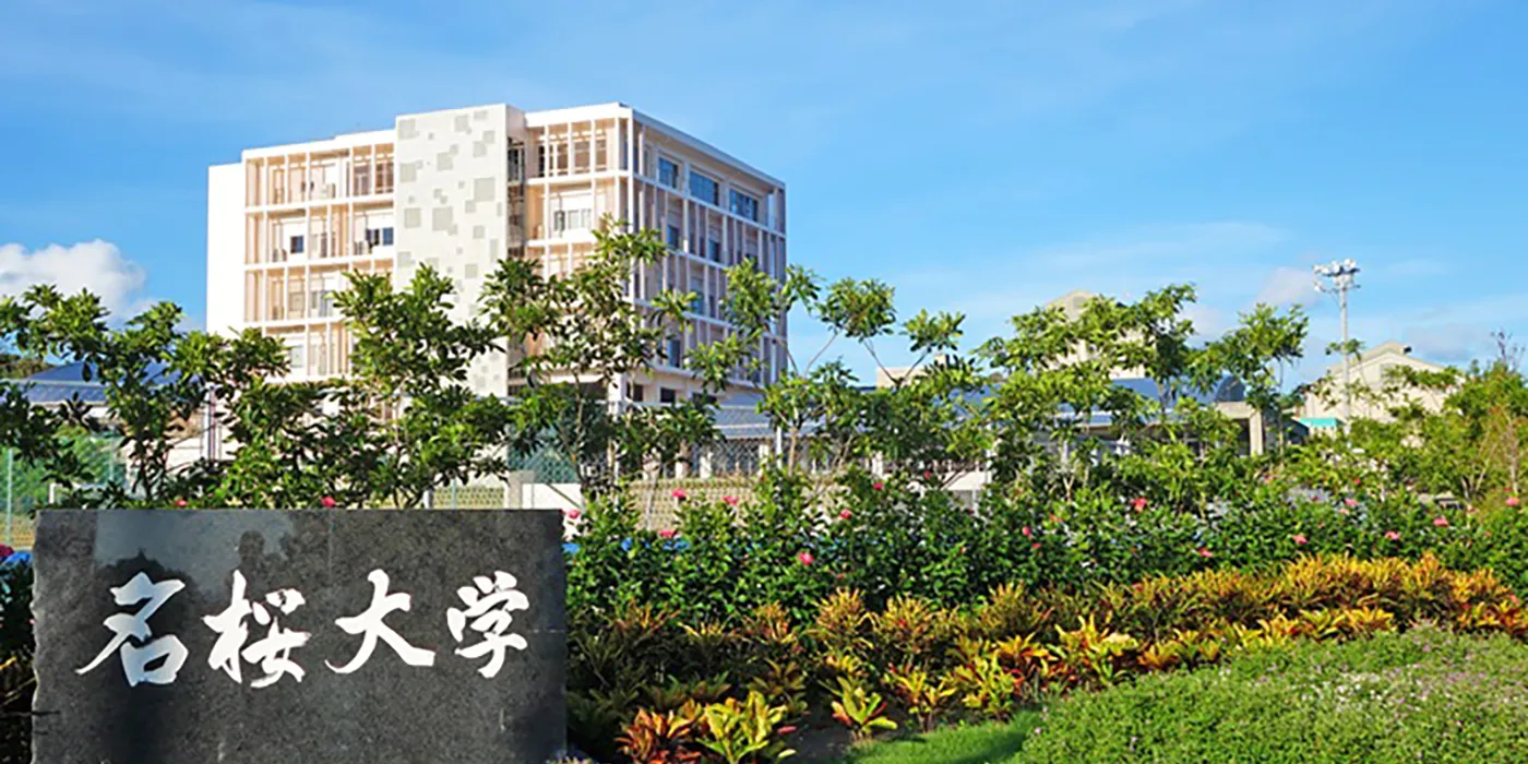 刻著名桜大學校名的石碑，後方是校舍